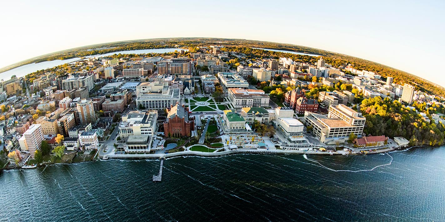 Lake Mendota and the University of Wisconsin-Madison campus, including the Memorial Union Terrace, are pictured in an early morning aerial taken from a helicopter on Oct. 23, 2018. This photograph was captured with a fisheye lens. (Photo by Bryce Richter /UW-Madison)