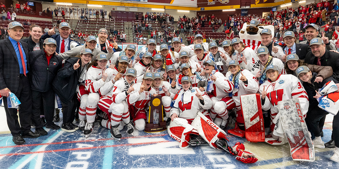 Wisconsin Women's Hockey team shown with their NCAA champion trophy